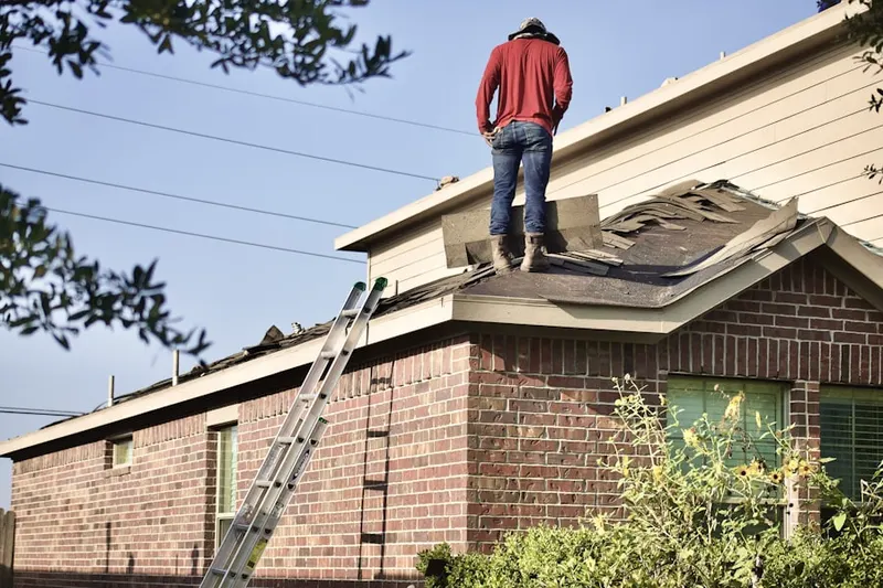 Professional roofer working on a residential roof in Lansing